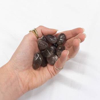 A handful of smokey quartz tumbles